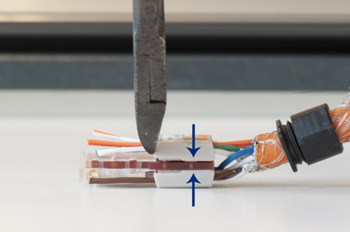 Zorg dat er geen overlengte van de massieve aders uit het ader-management systeem steken. Knip deze zo kort mogelijk af!