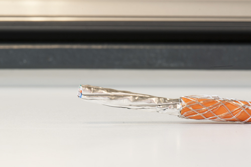 Vouw de metalen shielding naar achteren over de mantel zodat deze niet in de weg zit.